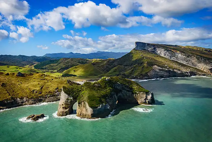 Golden Bay Air scenic flight with dramatic view of Archway Islands, Wharariki with Mt Luna in background