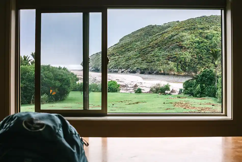 Lawn in front of Heaphy Hut with Heaphy River mouth in background