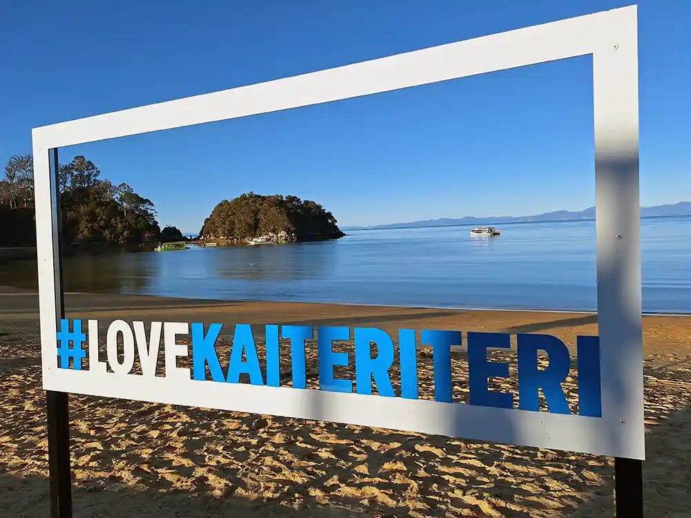 Kaiteriteri Beach viewed through #LOVEKAITERITERI frame sign
