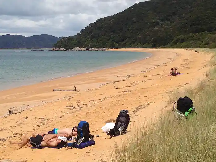 Walkers taking a break sunbaving on beach