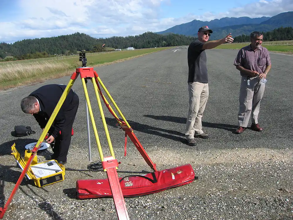 Surveyors with equipment at end of airport runway