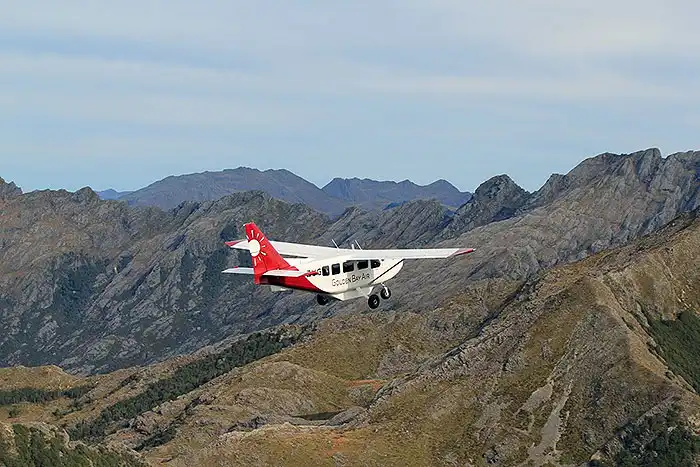 Golden Bay Air Airvan climbs towards the mountains of Kahurangi National