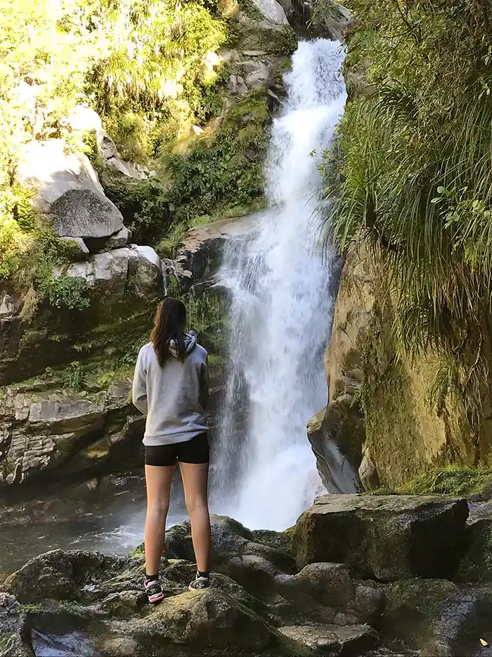 Girl standing looking at waterfall